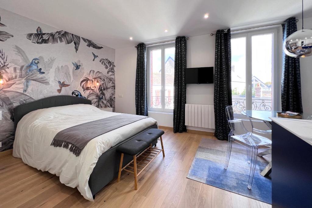 a bedroom with a large bed and a table in it at Appart 2 personnes à 50m des commerces & mer in Barneville-Carteret
