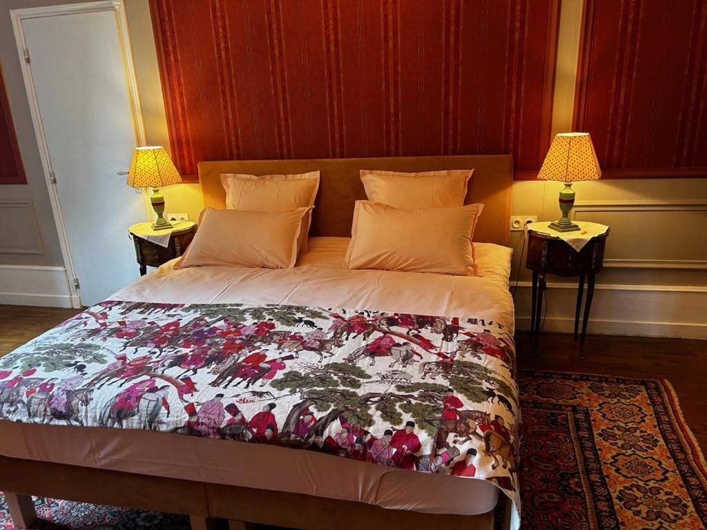 a bed in a bedroom with two lamps on two tables at Château de Mauvilly in Mauvilly