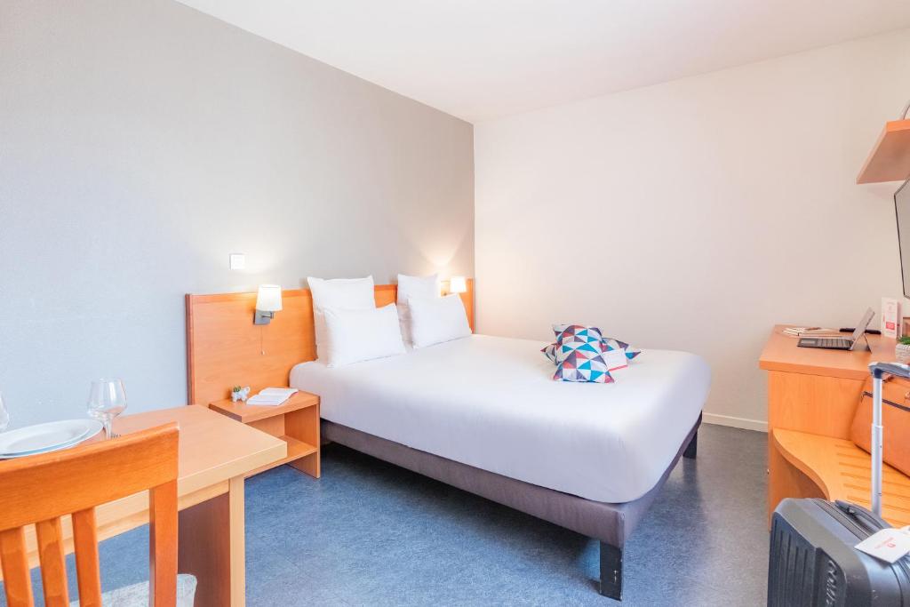 a hotel room with a bed and a desk at Appart’City Confort Lyon Gerland in Lyon