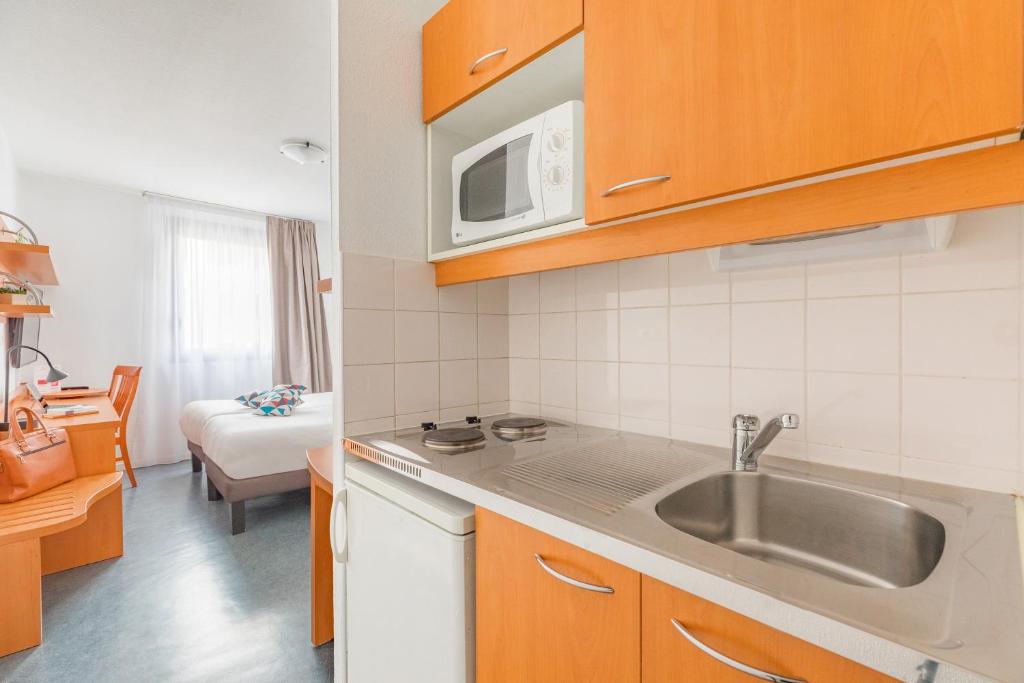 Kuchyň nebo kuchyňský kout v ubytování Appart’City Confort Lyon Gerland