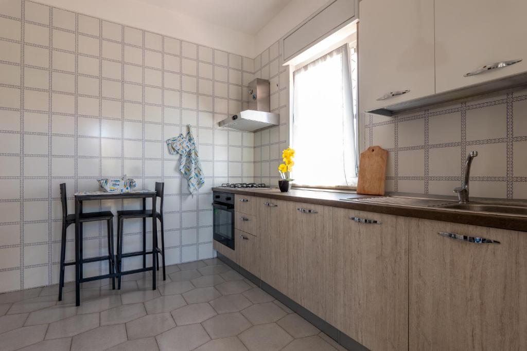 kuchnia ze zlewem, kuchenką i oknem w obiekcie Butterfly House w mieście Trappeto