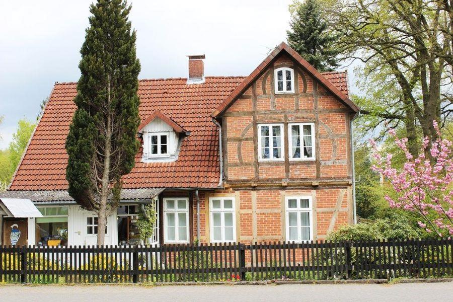een rood bakstenen huis met een zwart hek bij Bernsteinstube Wolf in Hermannsburg