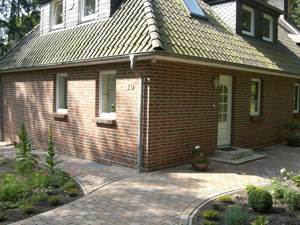 a small brick house with a white door at Ferienwohnung Am Hasenberg in Hermannsburg