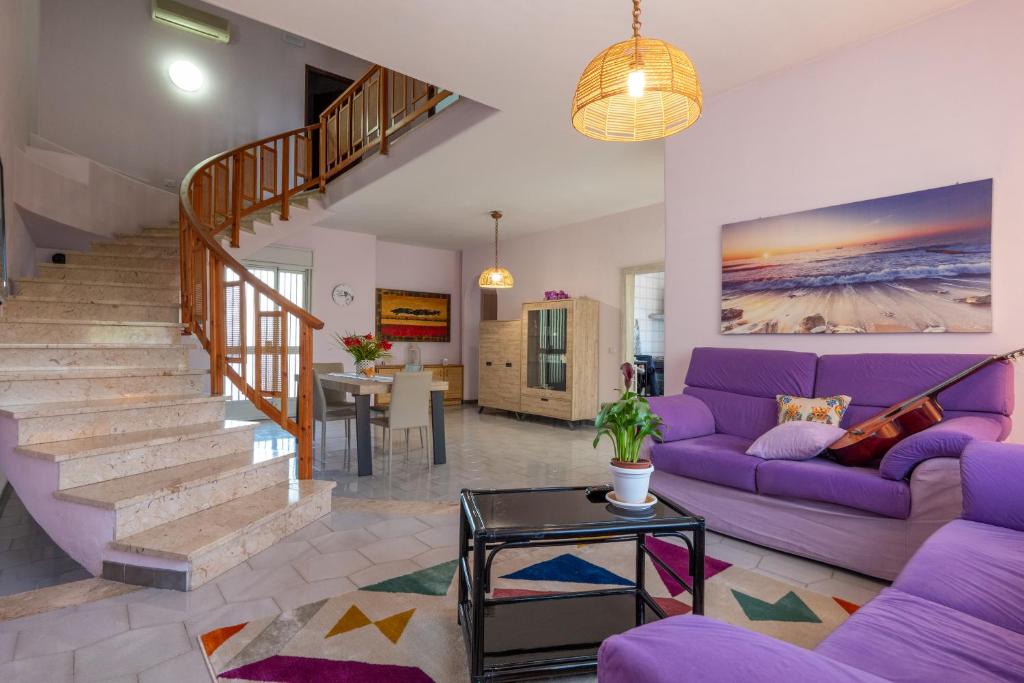salon z fioletowymi meblami i fioletową kanapą w obiekcie Butterfly House w mieście Trappeto