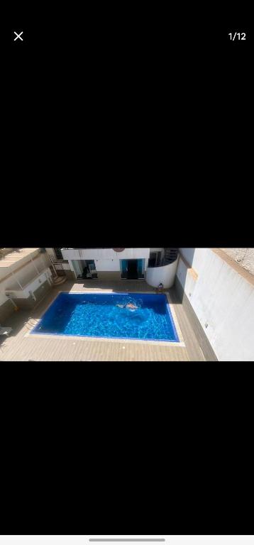 Oum el BouaghiにあるJijelの- 青い水を使用したバスタブ付きのスイミングプール