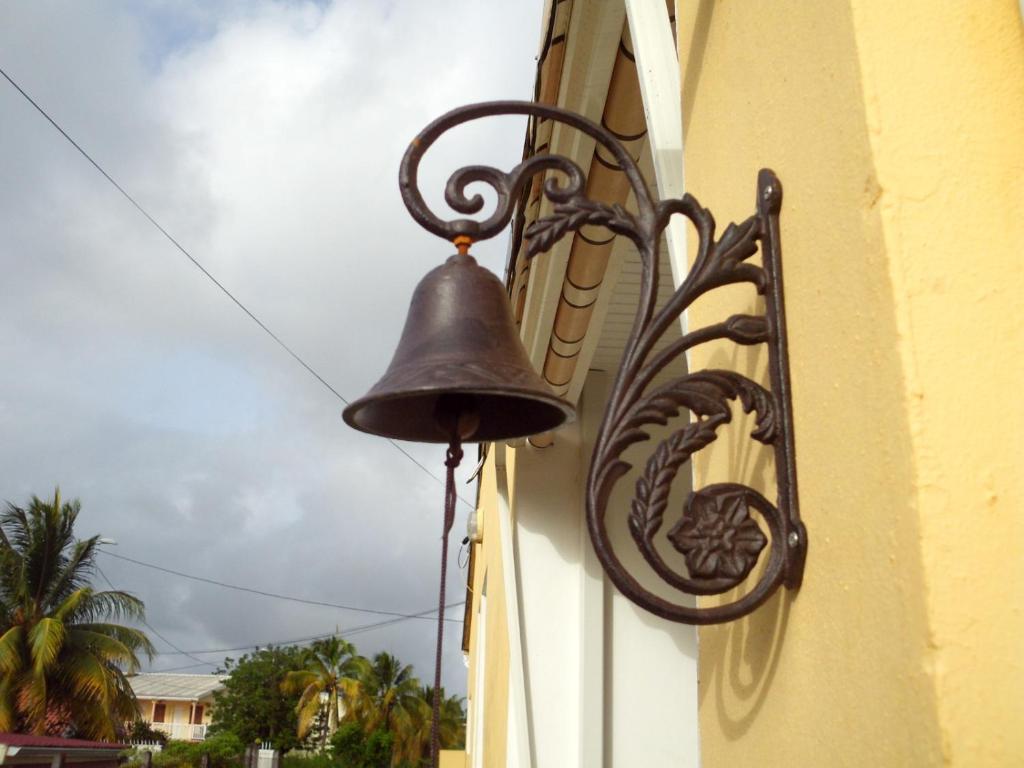 une cloche fixée sur le côté du bâtiment dans l'établissement Villa Ducos, à Ducos