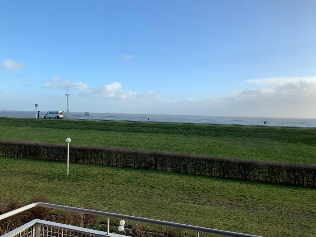 a view of a field with the ocean in the background at Apartment 10 in Wilhelmshaven