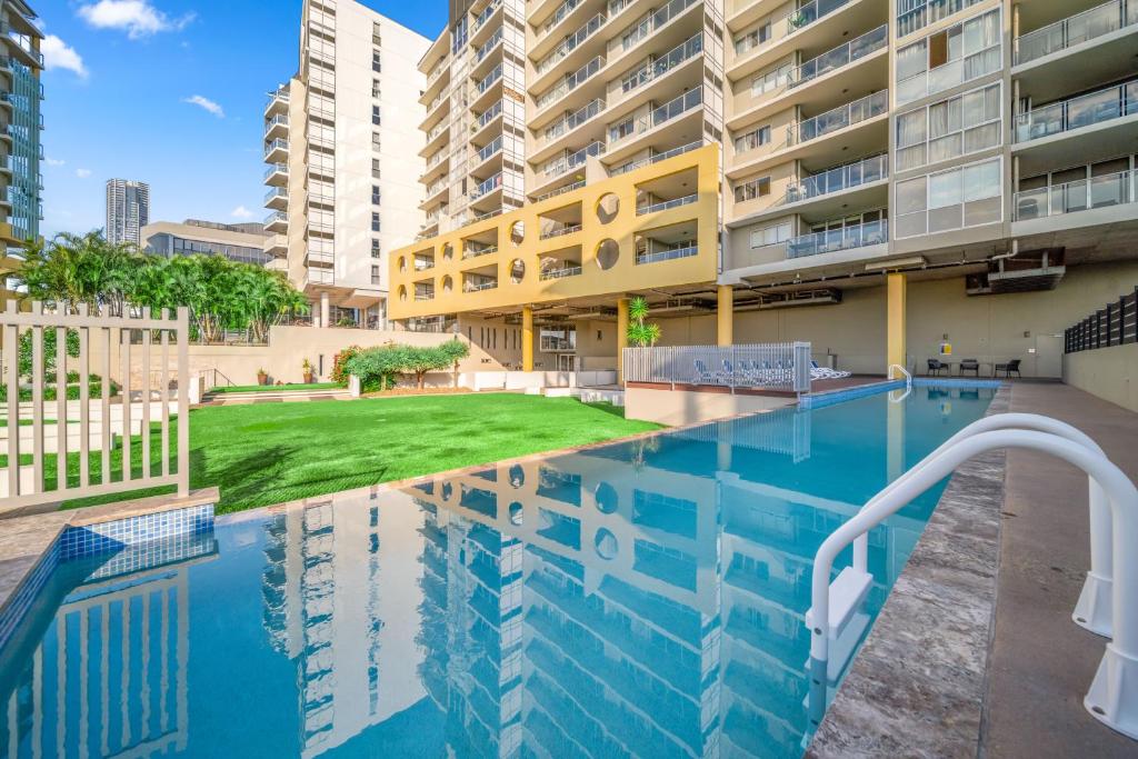 a swimming pool in front of a building at Oxygen Apartments in Brisbane