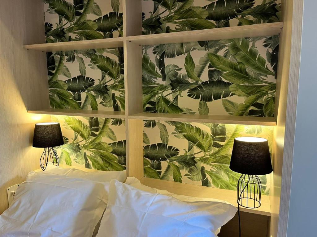a bedroom with a wall with a mural of leaves at Smart Living in Aveiro