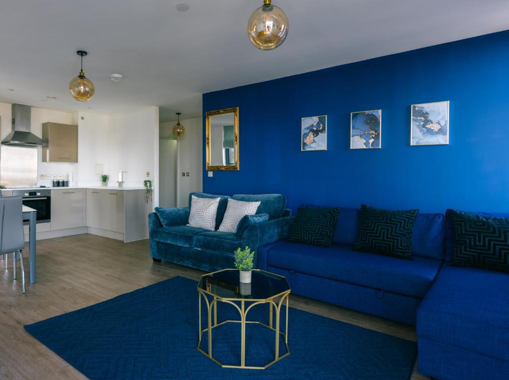 ein Wohnzimmer mit blauen Wänden und einem blauen Sofa in der Unterkunft Luxury Apartment Retreat - FREE Netflix And Wifi in Birmingham
