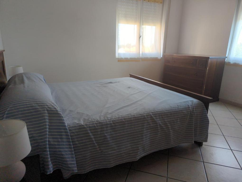 a bedroom with a bed and a dresser and a window at Agriturismo Cascina Rio Rocca in San Lorenzo al Mare