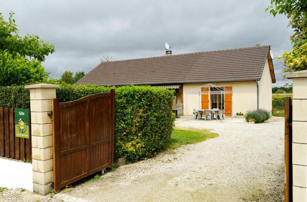 une maison avec une porte en bois et une clôture dans l'établissement Les fretees, à Laines-aux-Bois