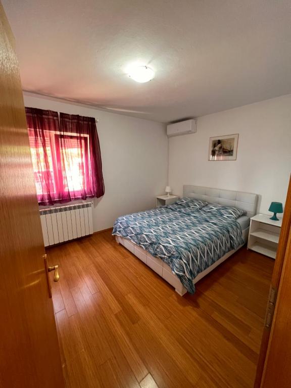 - une chambre avec un lit et du parquet dans l'établissement Apartments Gojević, à Crikvenica
