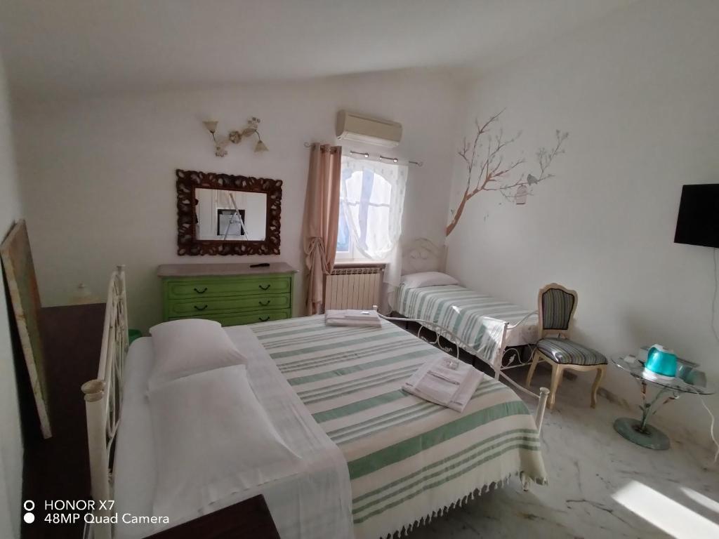 a bedroom with two beds and a dresser and a window at IL CASALE DEL MAGRA in Ameglia