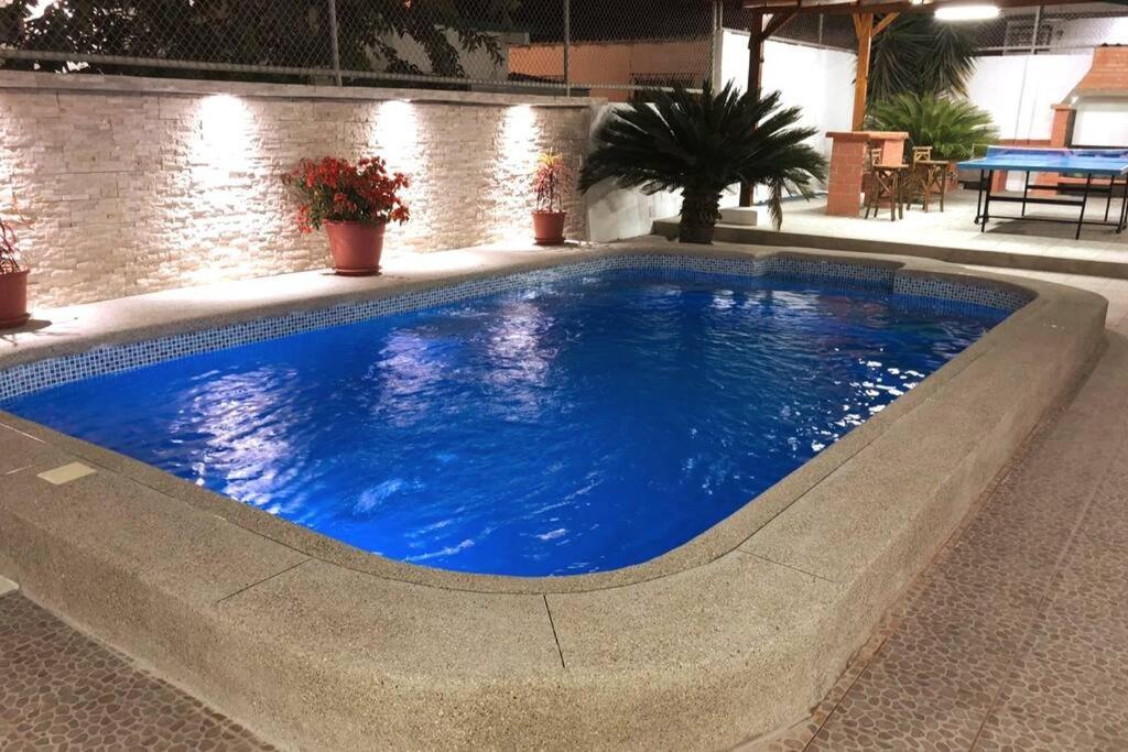 une grande piscine bleue dans un bâtiment dans l'établissement Casa en Ballenita: Piscina, Vóley, BBQ y Mar Cerca, à Ballenita