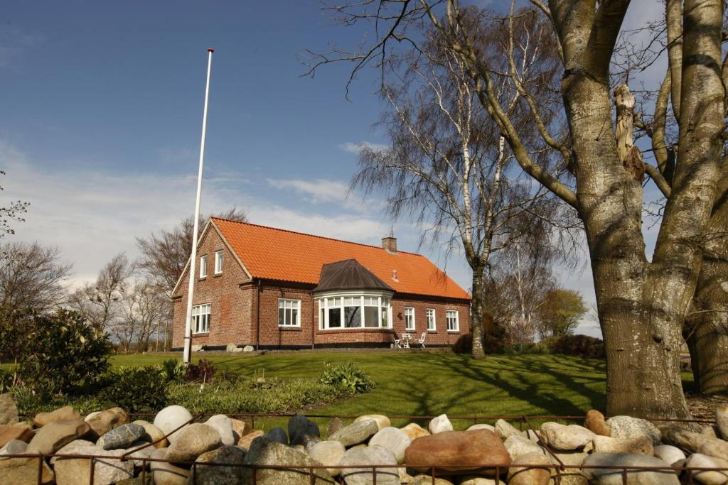 a brick house with an orange roof on a yard at Løftgård Bed and Bath in Ovtrup