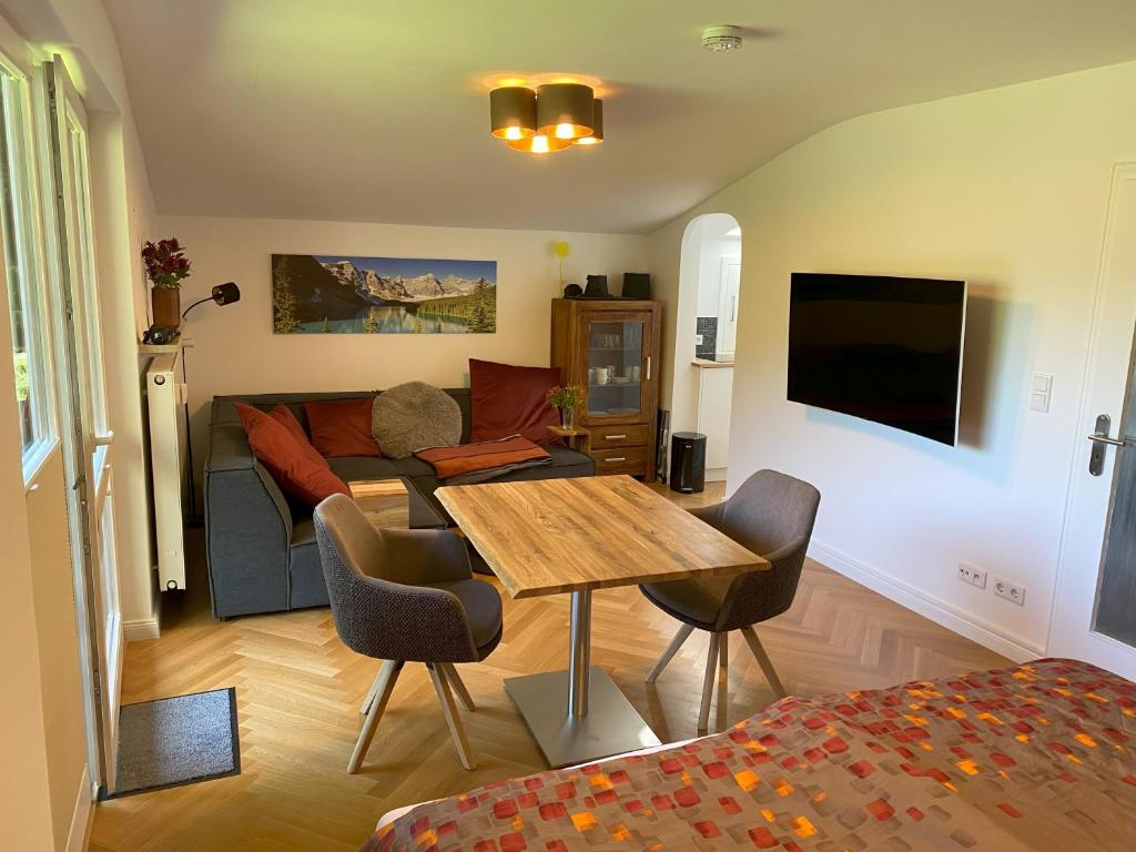 - un salon avec une table et un canapé dans l'établissement Apartment Perle am See - Wohnen auf Zeit - Homeoffice - nah am See - buchbar ab 28 Nächte, à Schliersee