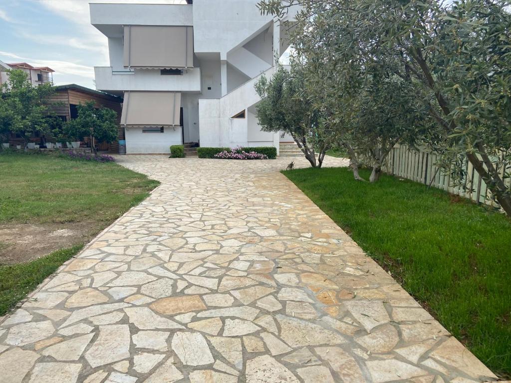 a stone walkway in front of a building at Ergys Apartments in Ksamil
