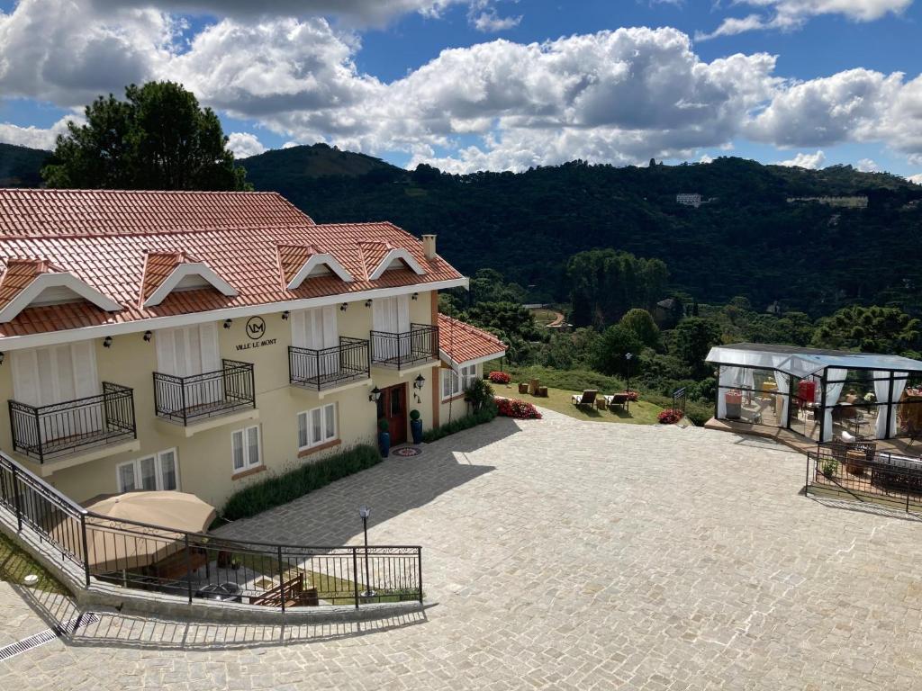 a large building with a large driveway in front of it at Pousada Ville Le Mont in Campos do Jordão