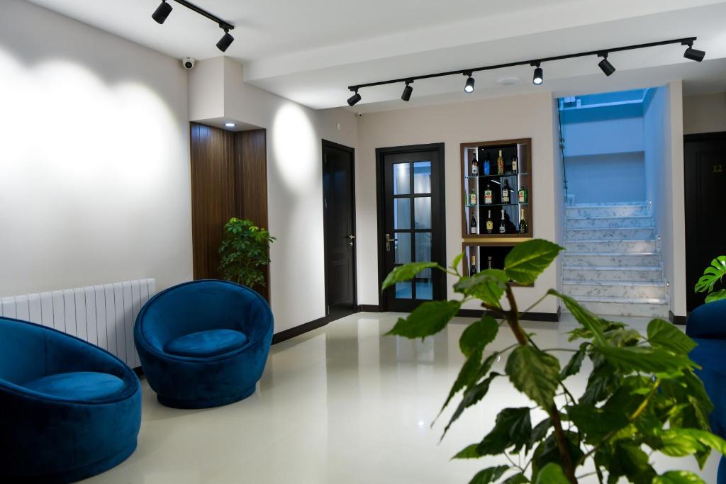 a living room with blue chairs and a plant at Euro Hotel Kutaisi in Kutaisi