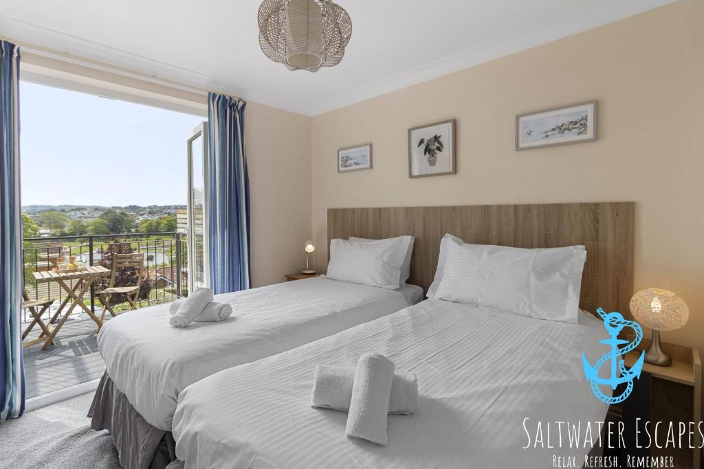 a bedroom with two beds and a balcony at Stella Marina in Paignton