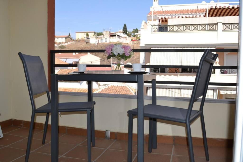 d'une table noire et de deux chaises sur un balcon. dans l'établissement Precioso apartamento en primera linea de playa, à Algarrobo-Costa