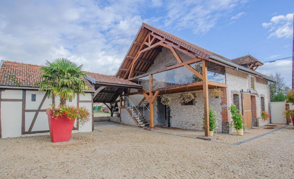una casa con techo de madera y palmera en La fontainate, en Payns