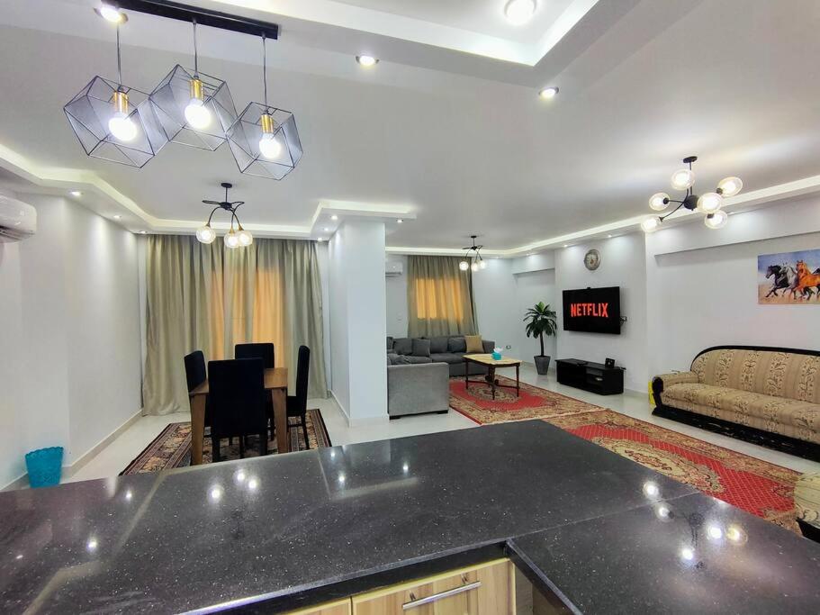 un salon avec une cuisine et un salon avec un canapé dans l'établissement Cozy Modern Apartment In El-Nozha, au Caire