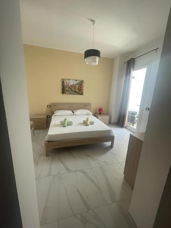 a bedroom with a bed and a large window at Camere Lorenzo in Porto Cesareo
