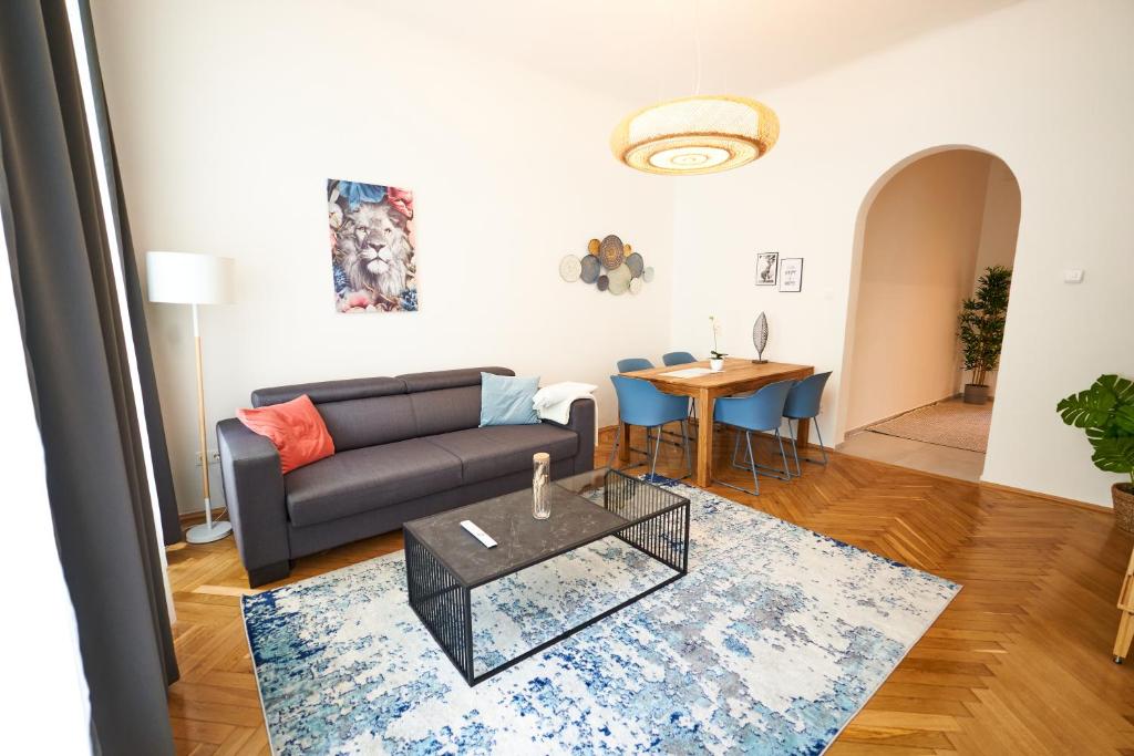 ein Wohnzimmer mit einem Sofa und einem Tisch in der Unterkunft Trendy Apartment 3 Zimmer zentral gelegen in Wien