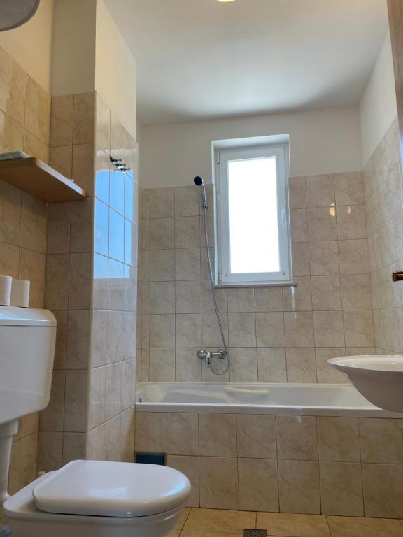 e bagno con servizi igienici, vasca e lavandino. di Apartaments Bee a Vinjerac (Castel Venier)