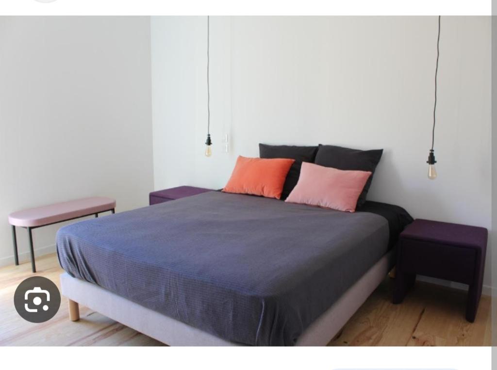 une chambre avec un lit avec deux oreillers et une table dans l'établissement Hébergement 24h le mans, au Mans