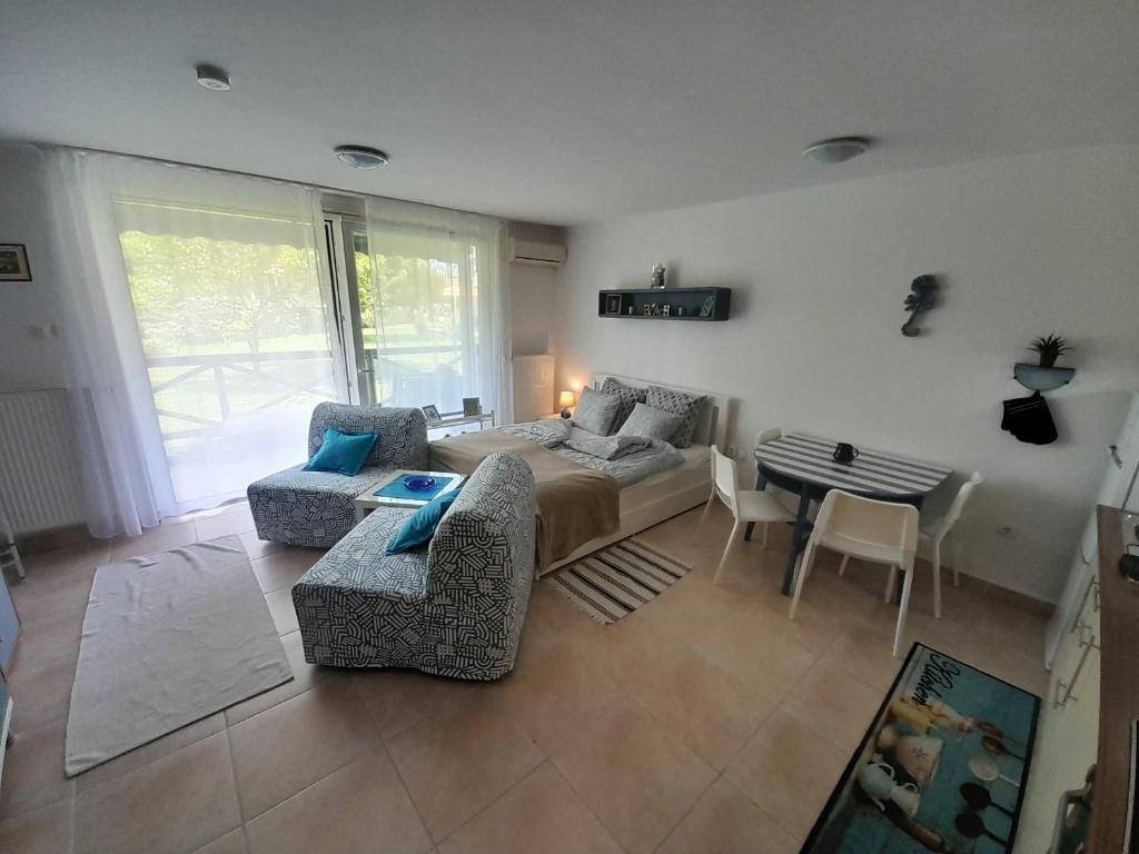 a living room with a couch and chairs and a table at Victoria Wave Apartman in Balatonőszöd