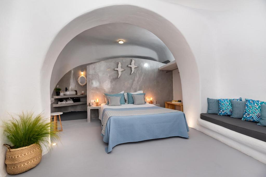 a bedroom with a blue bed and a couch at 1812 Caves 'n Mansion in Karterados