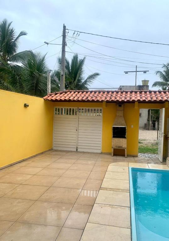 a yellow house with a pool in front of it at CASA DE PRAIA COM PISCINA EM ILHÉUS-BA a 50m DA PRAIA in Ilhéus