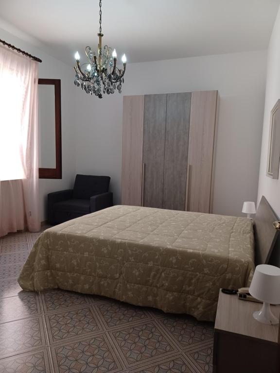 1 dormitorio con cama y lámpara de araña en Casa Grace Appartamento 2, en Mazara del Vallo
