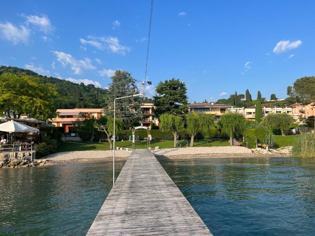 a wooden bridge over a body of water at Favola Bella The panoramic penthouse in Bardolino