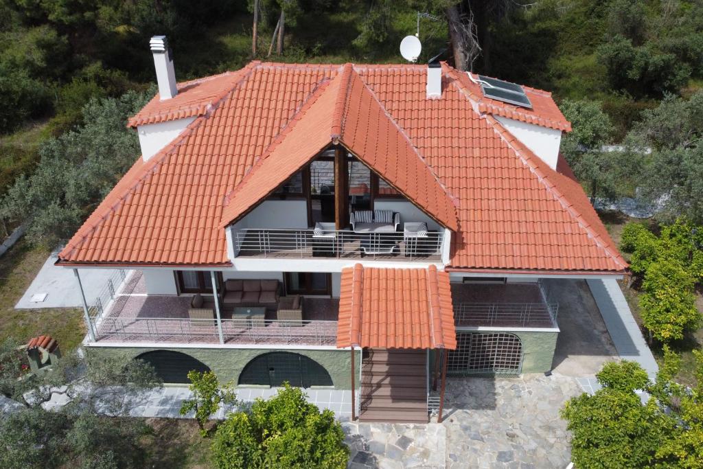 widok z powietrza na dom z pomarańczowym dachem w obiekcie Villa Alex w miejscowości Agios Georgios