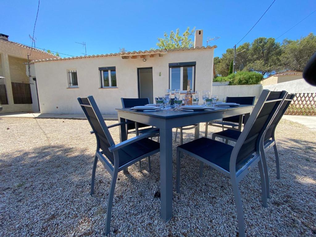une table avec des chaises devant une maison dans l'établissement Maison de L'Étang de Berre, à Saint-Mitre-les-Remparts