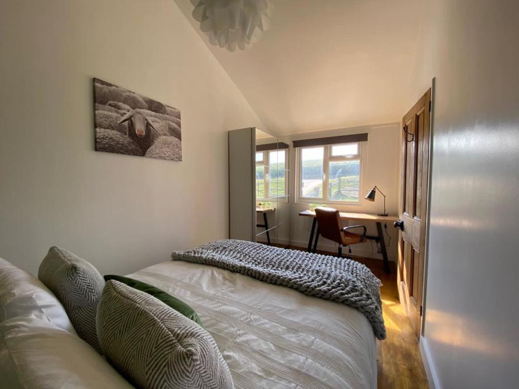 a bedroom with a bed and a desk and a window at Beachside Bliss Cosy Cottage Jurys Gap in Rye