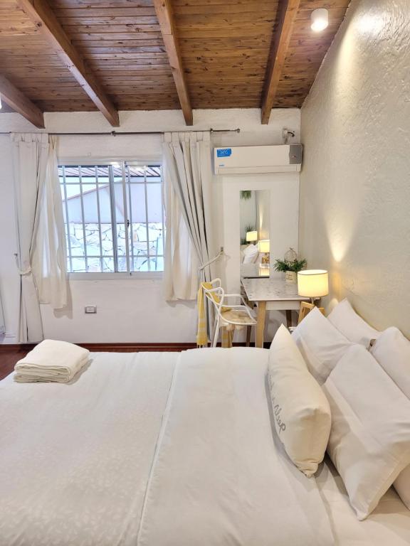 een groot wit bed in een kamer met een tafel bij "Casa Amalia Apartamentos" Plaza Italia y Av Arístides a 50mts, lugar con jardín in Mendoza