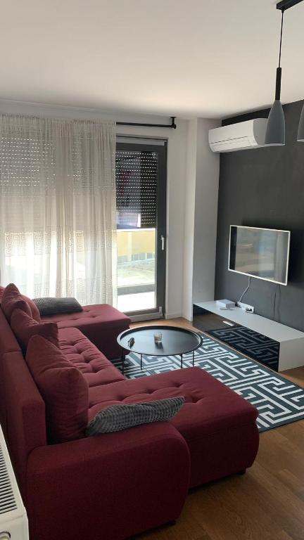 a living room with a red couch and a tv at Penthause StAnto, novogradnja, blizina Maksimira in Zagreb