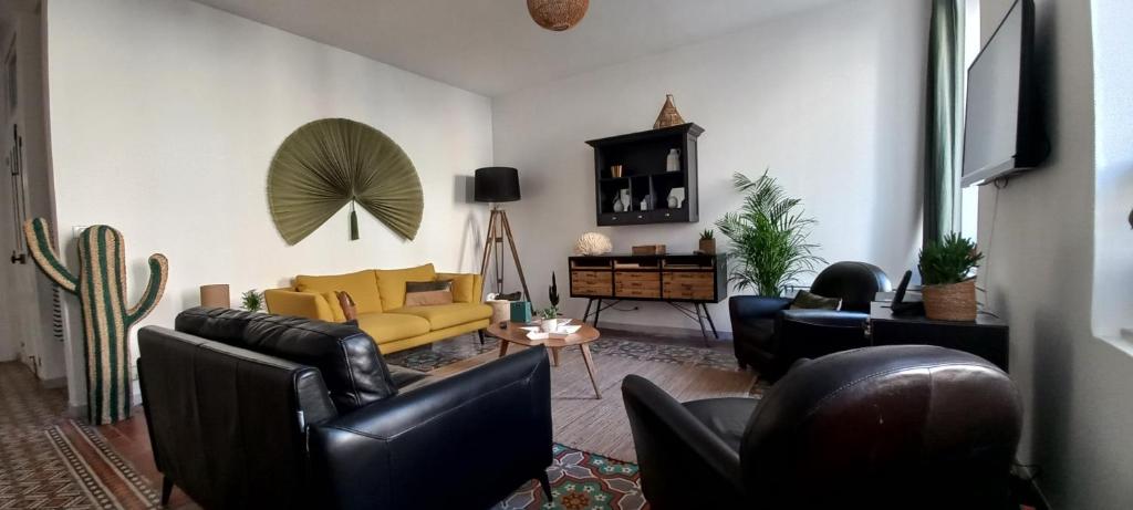 sala de estar con muebles de cuero y sofá amarillo en La maison de Malaurie en Gruissan