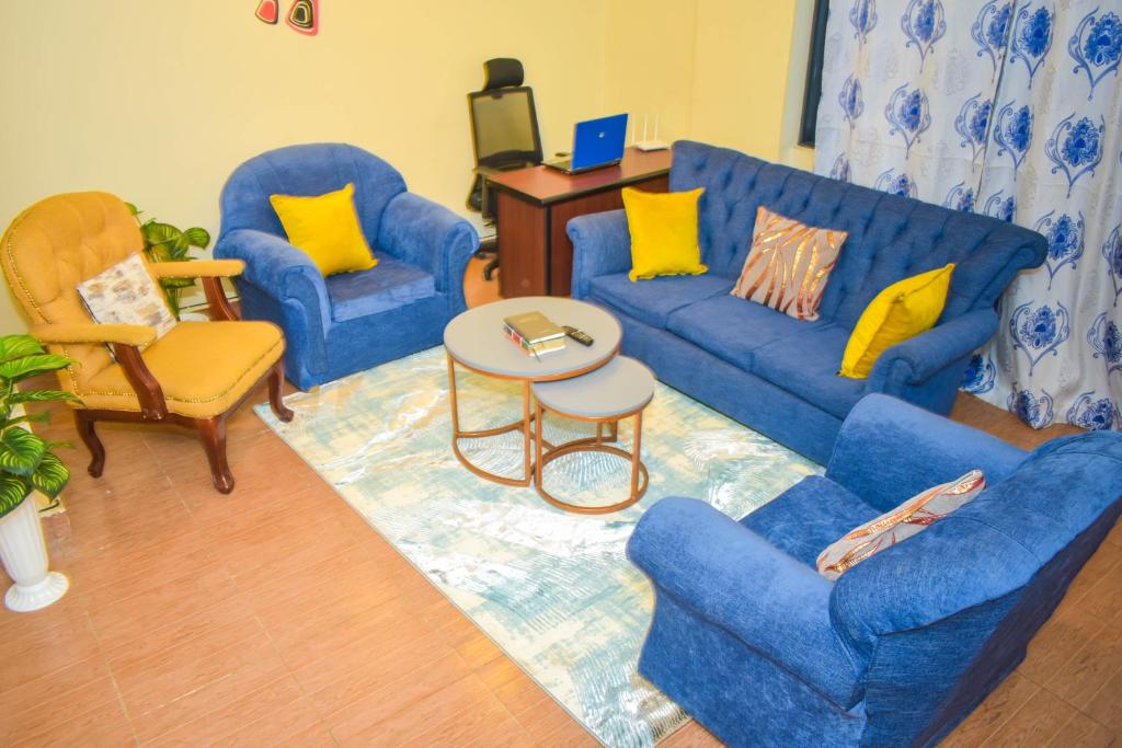 - un salon avec deux canapés bleus et une table dans l'établissement Lux Suites 2 Bedroom Diamonte Apartment Ngara, à Nairobi