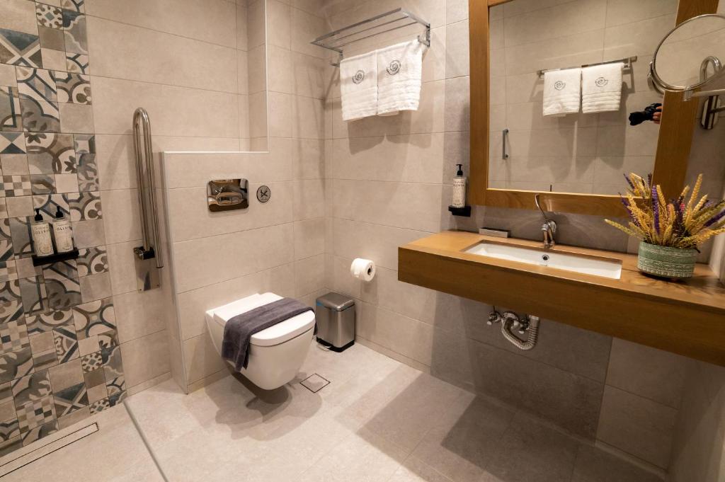 a bathroom with a toilet and a sink and a shower at Nissos Apartments in Myrina