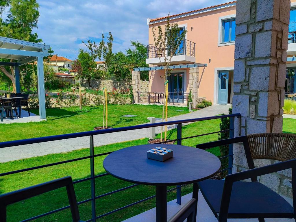 a table and chairs on a balcony with a yard at Nissos Apartments in Myrina
