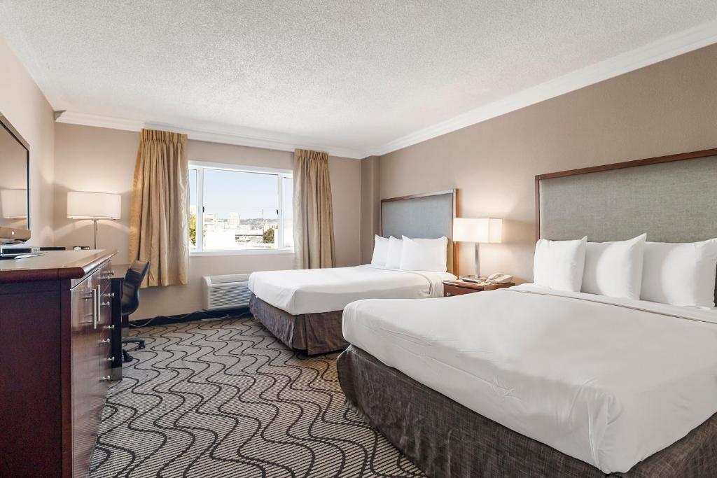 a hotel room with two beds and a window at Jack London Inn in Oakland