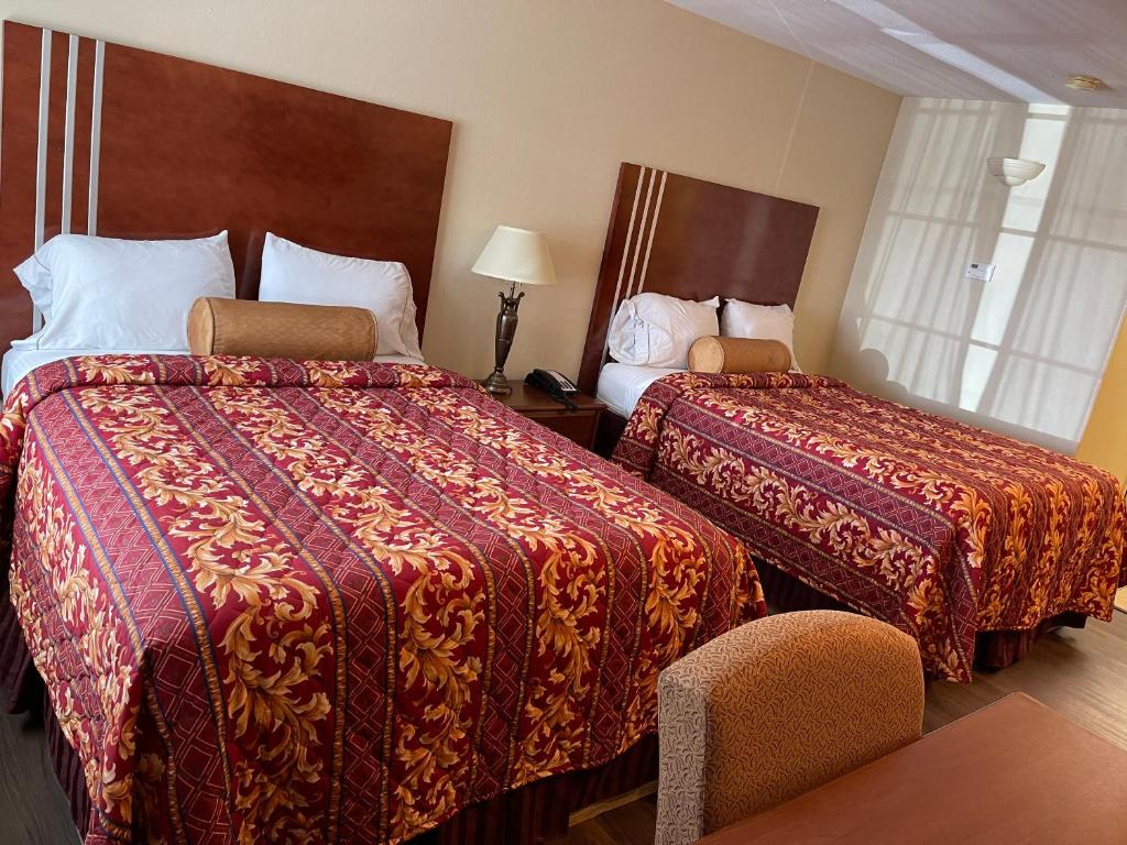 una habitación de hotel con 2 camas y una silla en Riviera Inn and Suites en Riviera