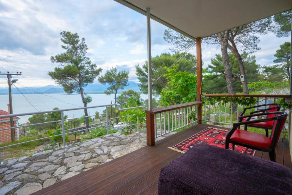 a room with a balcony with a view of the water at AMONG THE TREES in Široka