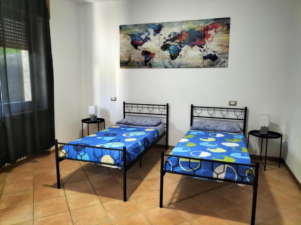 two beds in a room with a painting on the wall at Casa Degli Ulivi in Lazise